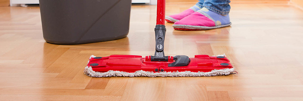 Roter Wischmop auf Parkett